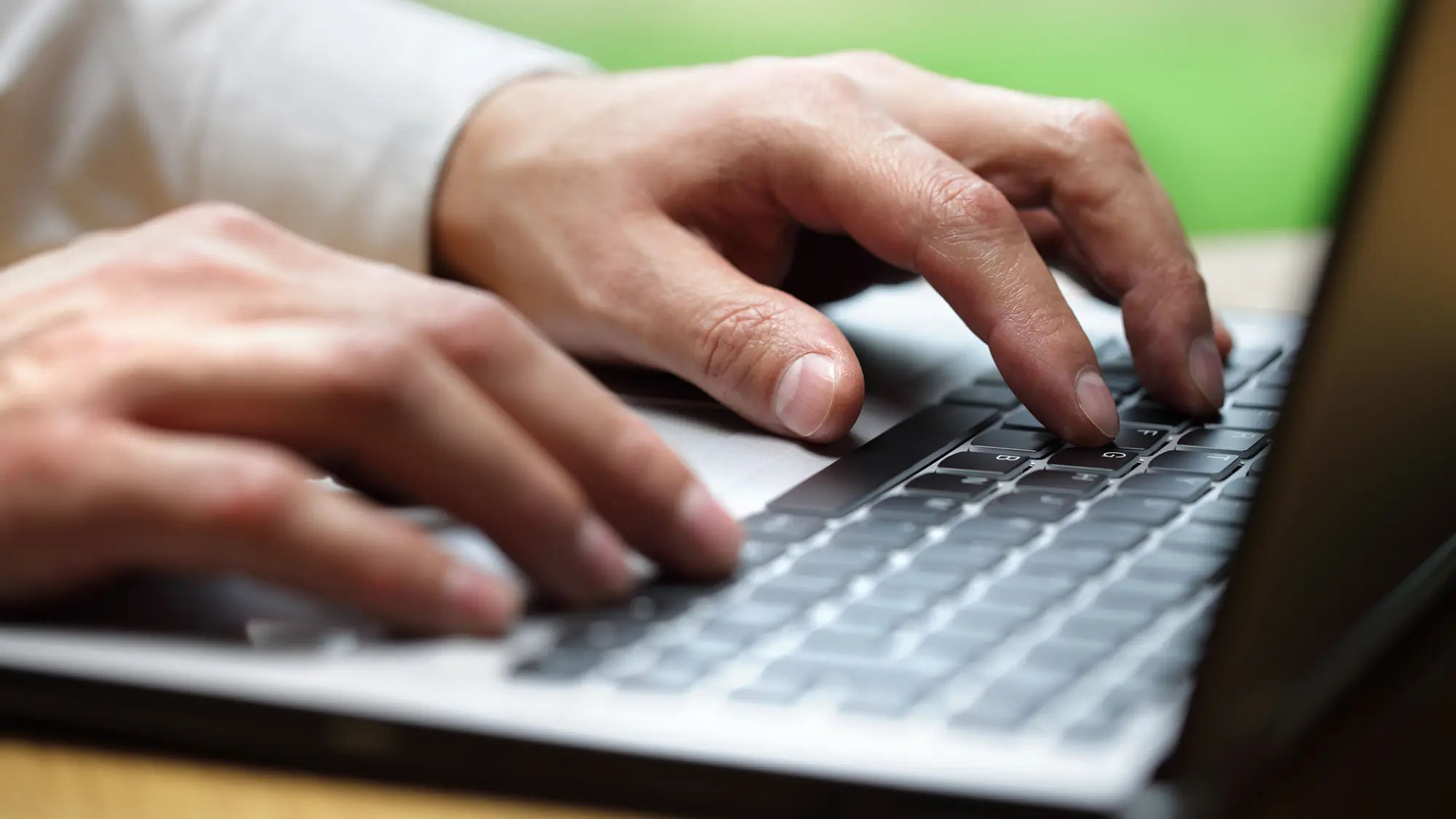 Hände tippen am Laptop